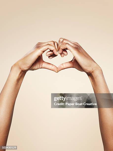 hands forming a cute heart shape - symbole amoureux photos et images de collection