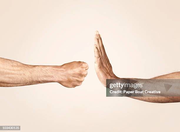 hands symbolizing defensive and offensive force - abwehr stock-fotos und bilder