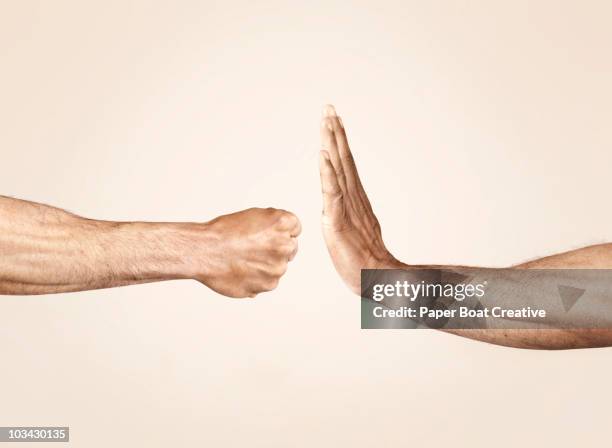 hands symbolizing defensive and offensive force - handgebaar stockfoto's en -beelden