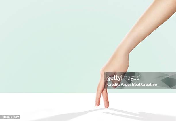 hands walking across a bright white surface - finger stock pictures, royalty-free photos & images