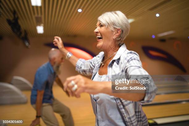 senior woman celebrating at ten-pin bowling - bowling stock pictures, royalty-free photos & images