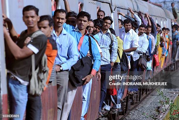 Commuters travel by local train in Mumbai on February 24, 2010 as Indian Railways Minister Kumari Mamata Banerjee presents the railway budget for the...