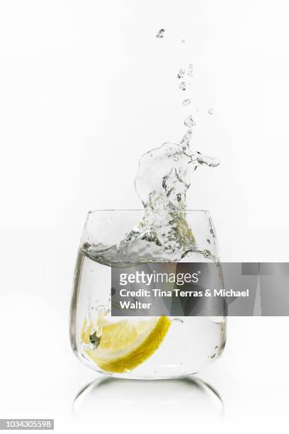 water splash. a glass of water with lemon slice. - 2018 glasses stockfoto's en -beelden