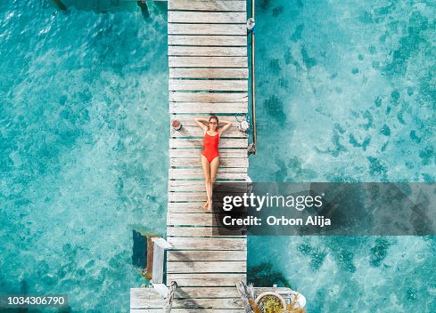 Luftaufnahme von Womann entspannend in einem Wasser-bungalow Luftaufnahme von Womann entspannend in einem Wasser-bungalow