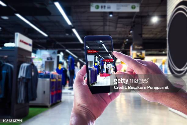 augmented reality marketing concept. hand holding digital tablet smart phone use ar application to check special sale price in retail fashion shop mall - digital store imagens e fotografias de stock