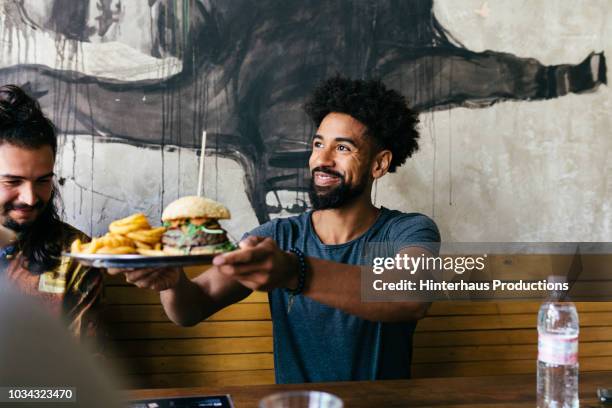 customer receiving food at burger restaurant - man eating - fotografias e filmes do acervo