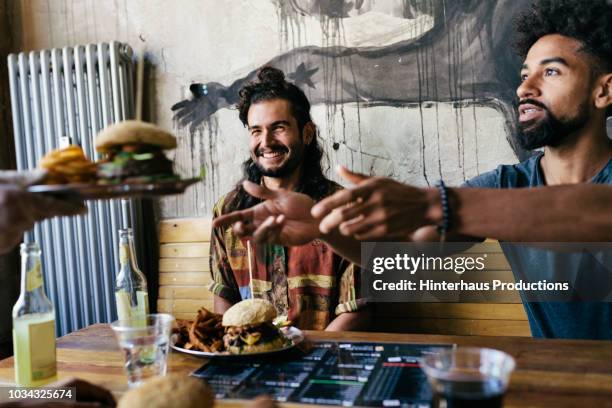 waiter handing burger to customer - male burger eating stock pictures, royalty-free photos & images