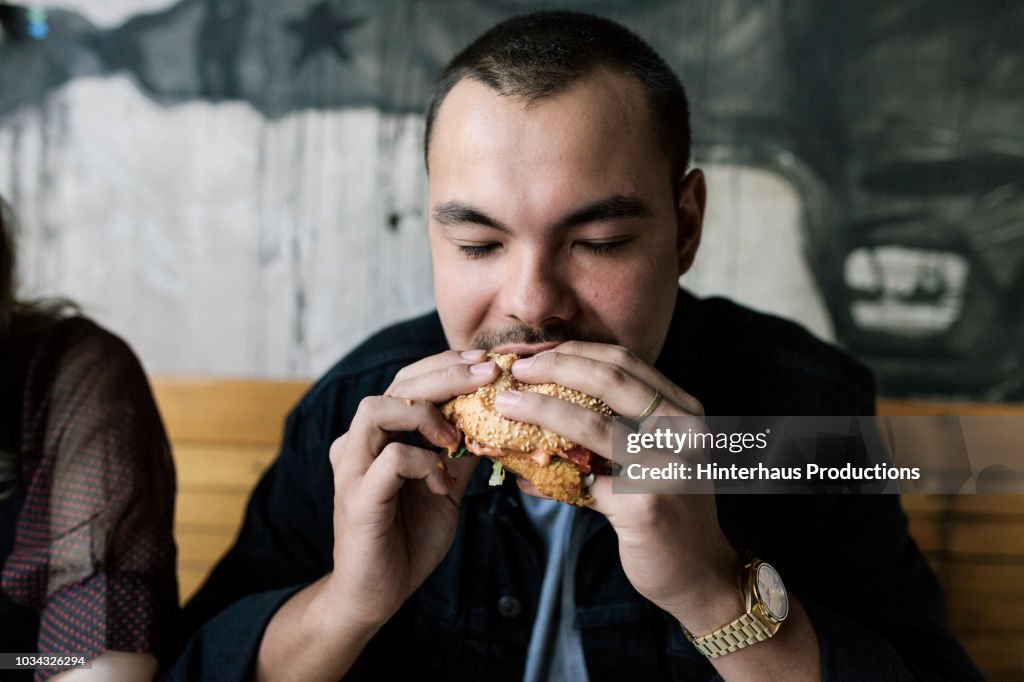 Young Man Eating A Burger