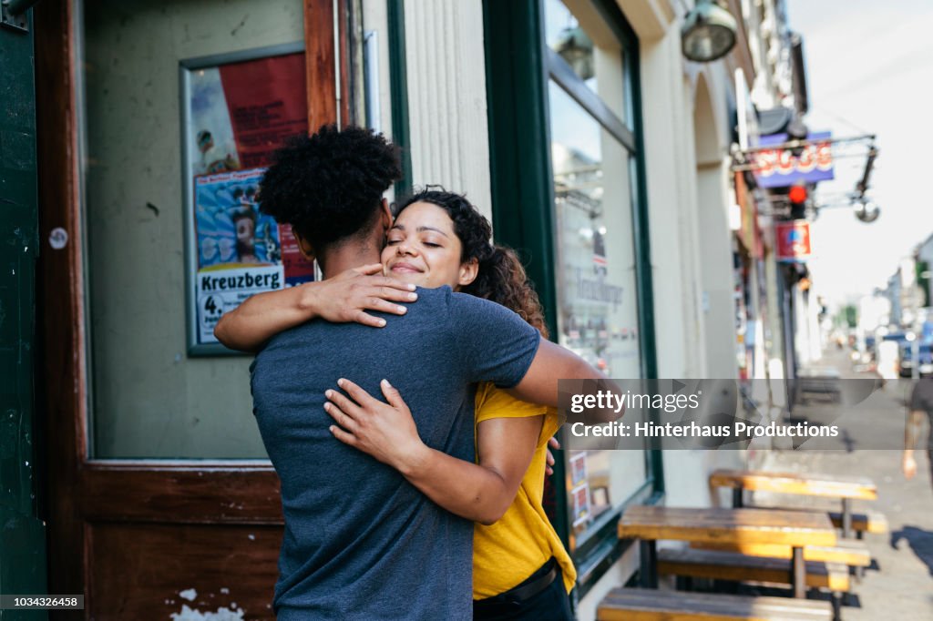 Friends Embracing Outside Restaurant