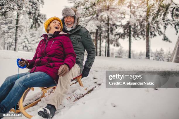 sledding time - active seniors winter stock pictures, royalty-free photos & images