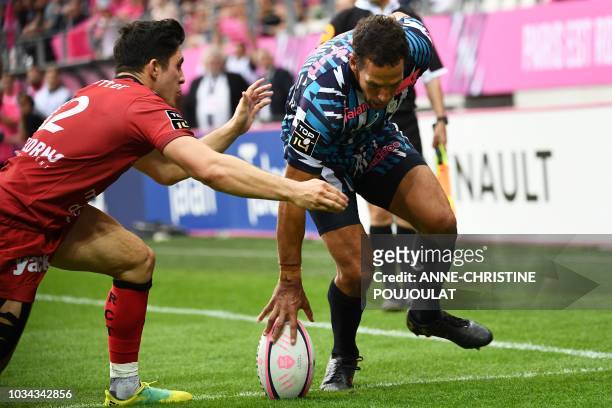 Stade Francais Paris' French winger Julien Arias touches down in spite of RC Toulon's French flyhalf Anthony Belleau during the French Top 14 rugby...