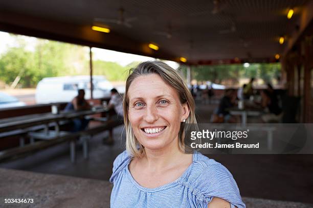 smiling blonde lady standing outside pub - australia women bildbanksfoton och bilder
