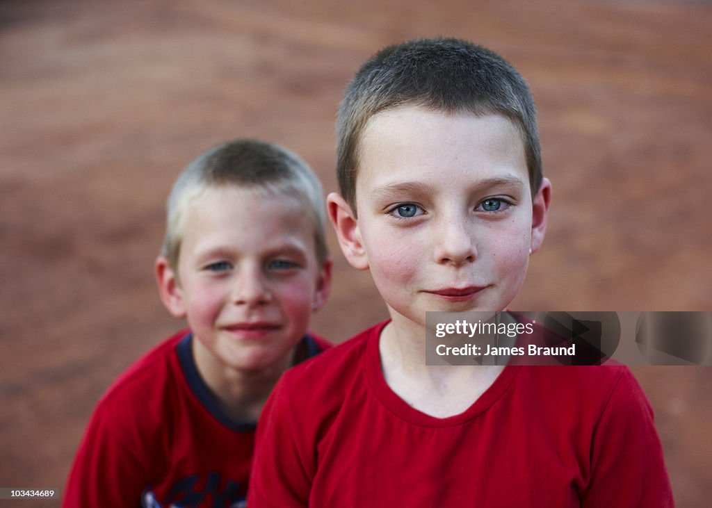 Two boys in red shirts facing camera