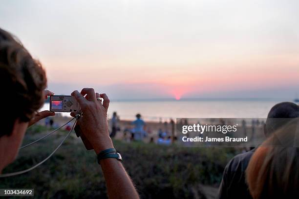 woman photographing sunset - darwin australia stock pictures, royalty-free photos & images