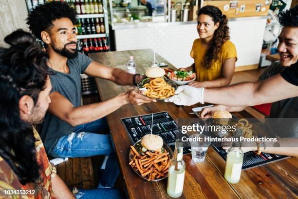 waiter serving burgers to customers - indian dish stock pictures, royalty-free photos & images