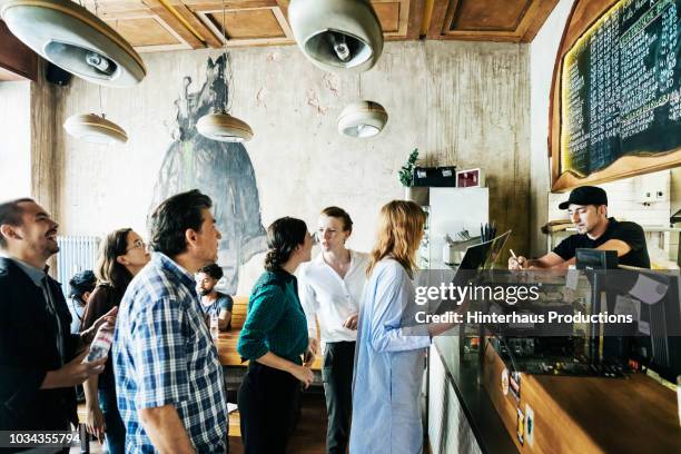 people waiting in line in busy burger restaurant - 人の列 ストックフォトと画像