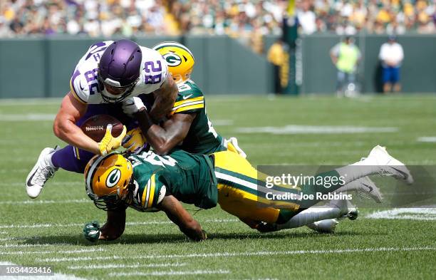 Kyle Rudolph of the Minnesota Vikings gets tackled during the first quarter of a game against the Green Bay Packers at Lambeau Field on September 16,...