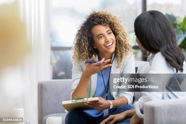 alentar las conversaciones de terapeuta con mujer joven - clipboard fotografías e imágenes de stock