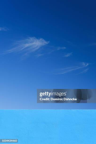 blue wall with blue sky - aire fotografías e imágenes de stock