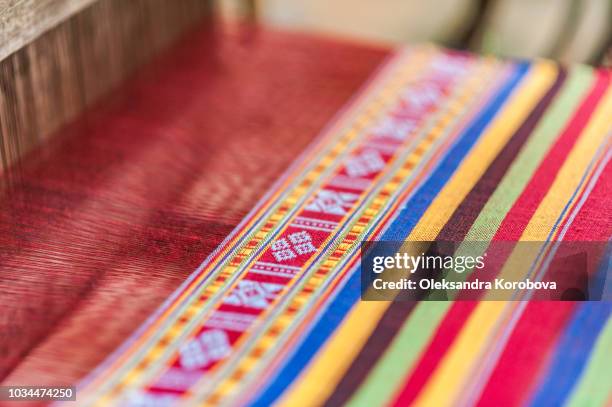 local woman diligently working at a loom, weaving colourful brocade fabric in lac village, mai chau valley, vietnam. - loom stock pictures, royalty-free photos & images