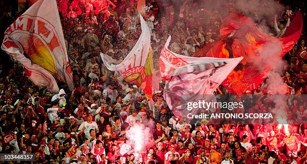 Fans of Brazil's Internacional wave their flags cheering their team before the start of the Libertadores Cup final against Mexico's Chivas on August...