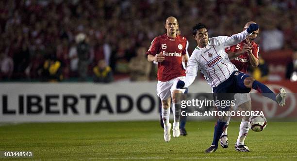 Brazil's Internacional footballer Guinazu vies for the ball with Dionisio Moreno of Mexico's Chivas, during their Libertadores Cup final on August 18...