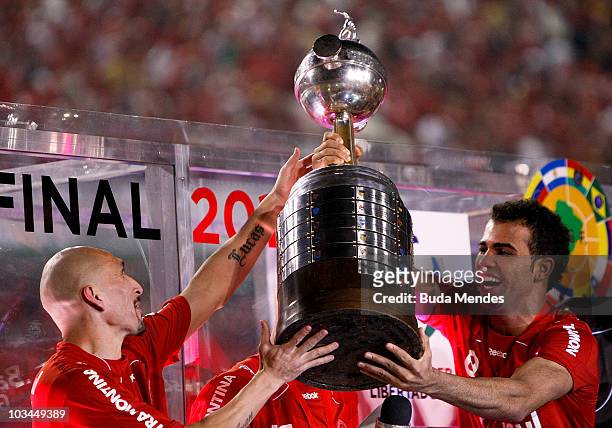 Guinazu and Sandro of Internacional hold the championship trophy after defeating Chivas during a final match as part of the 2010 Copa Santander...