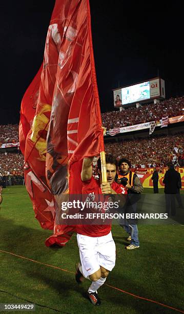 Brazilian Internacional's footballer Rafael Sobis holds a flag after the Libertadores Cup final football match against Mexican Chivas at Beira Rio...