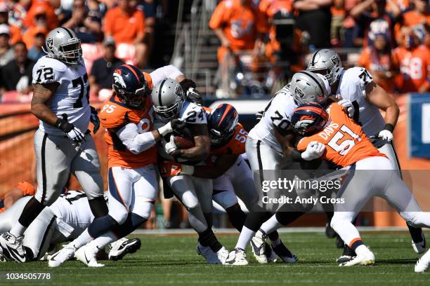 Derek Wolfe and Bradley Chubb of the Denver Broncos tackle Marshawn Lynch of the Oakland Raiders during the first quarter. The Denver Broncos hosted...