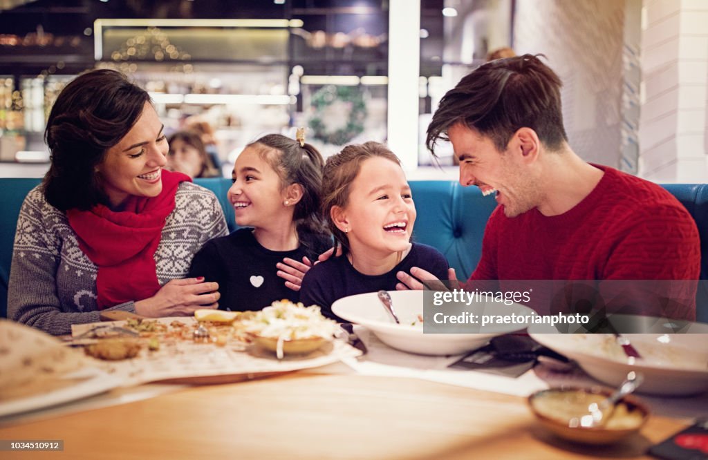 Portrait of happy family eating in the restaurant at Christmas