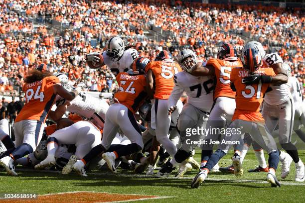 Marshawn Lynch of the Oakland Raiders leaps over the line for a touchdown during the second quarter against the Denver Broncos. The Denver Broncos...