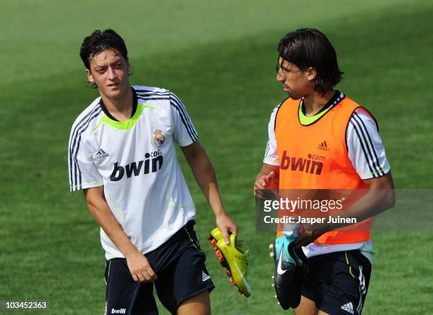 New signing Mesut Ozil of Real Madrid chats with his fellow countryman Sami Khedira at the end of a training session at the Valdebebas training...