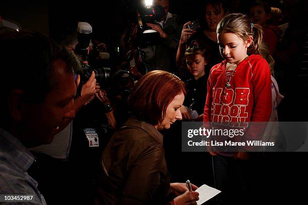 Prime Minister Julia Gillard signs an autograph for a young supporter at the Raymond Lakeside Tavern during the final week of campaigning ahead of...