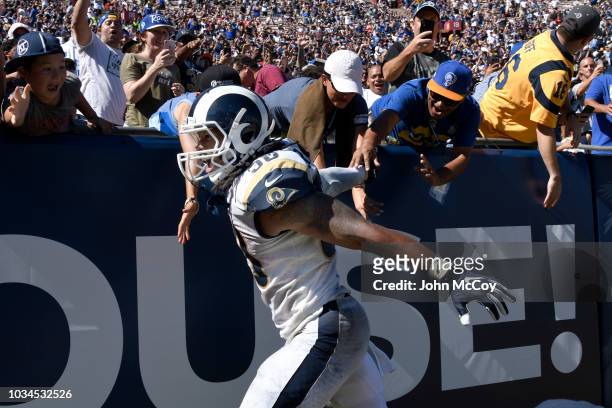 Todd Gurley of the Los Angeles Rams celebrates with fans after a second quarter Touchdown against the Arizona Cardinals Memorial Coliseum on...