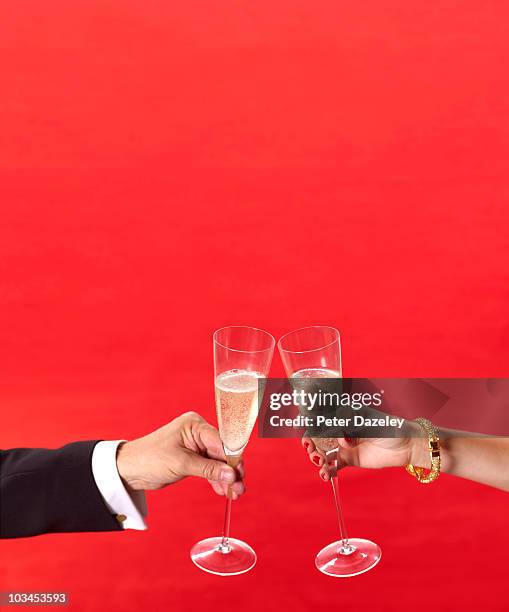 champagne glasses toasting at red carpet event - holding two things foto e immagini stock