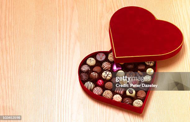 heart shaped chocolates on wood background - chocolate pieces stock-fotos und bilder