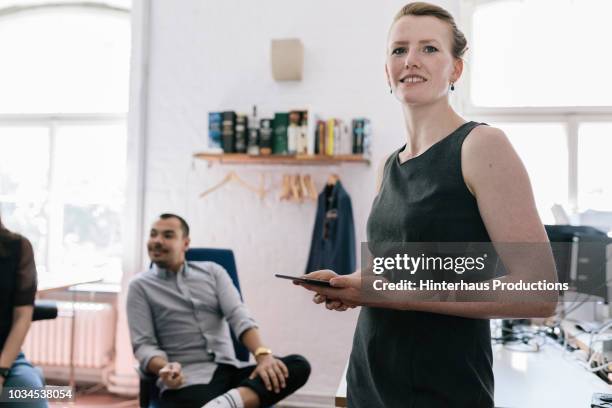 woman talking to colleagues during business meeting - sleeveless stock pictures, royalty-free photos & images