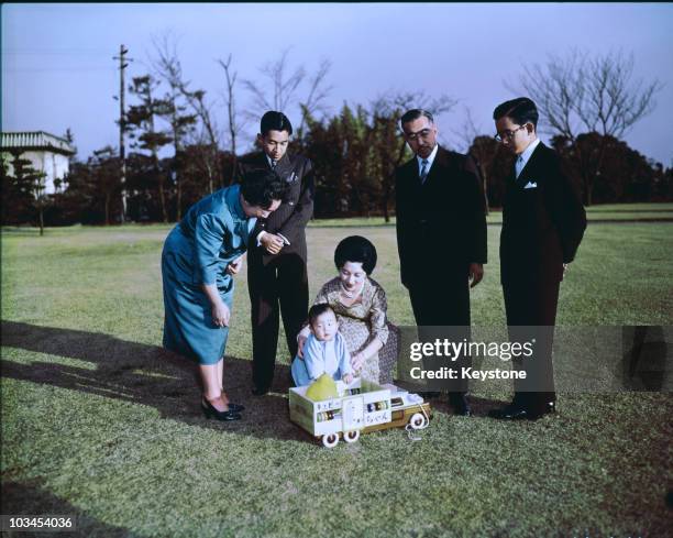 Empress Nagako, Crown Prince Akihito, baby Prince Hiro , Princess Michiko, Emperor Hirohito and Prince Hitachi in the gardens of the Imperial Palace...