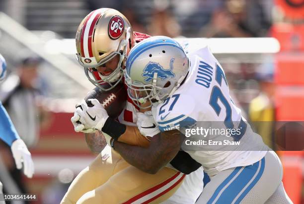 Garrett Celek of the San Francisco 49ers powers in for a touchdown after catching a pass while defended by Glover Quin of the Detroit Lions at Levi's...