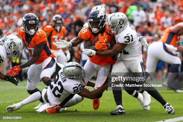 Wide receiver Demaryius Thomas of the Denver Broncos is hit by defensive back Rashaan Melvin and defensive back Marcus Gilchrist of the Oakland...