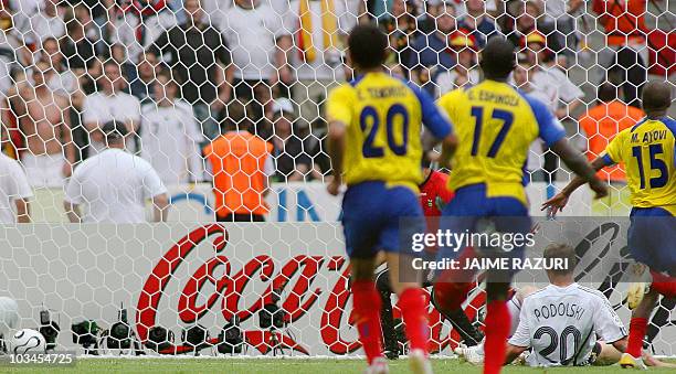 German forward Lukas Podolski lies down after scoring a goal as Ecuadorean defender Giovanny Espinoza , midfielder Edwin Tenorio , midfielder Marlon...