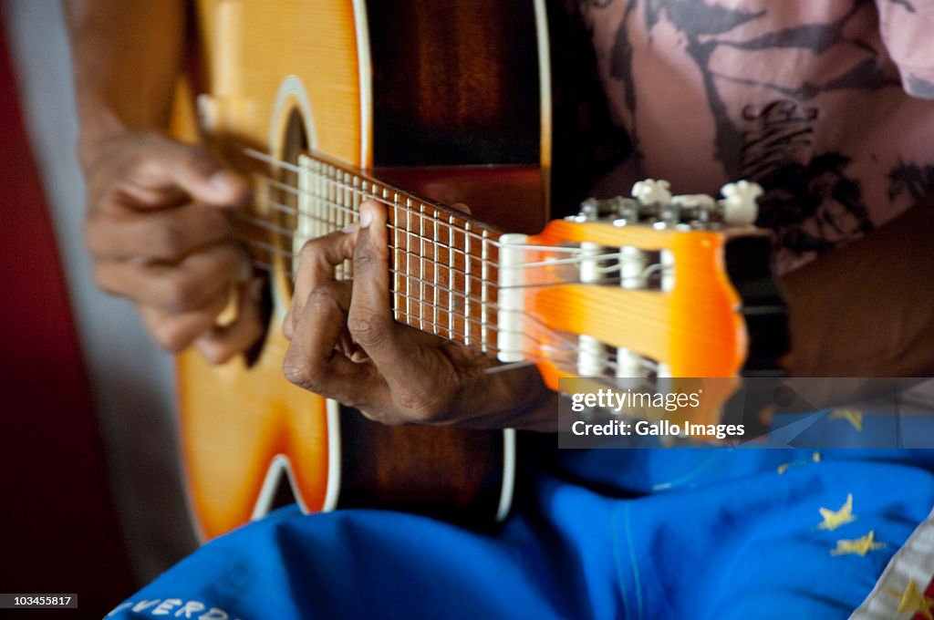 Musician playing guitar on local guitar makers workshop & studio, Mindelo (Porto Grande), Sao Vicente, Cape Verde Islands
