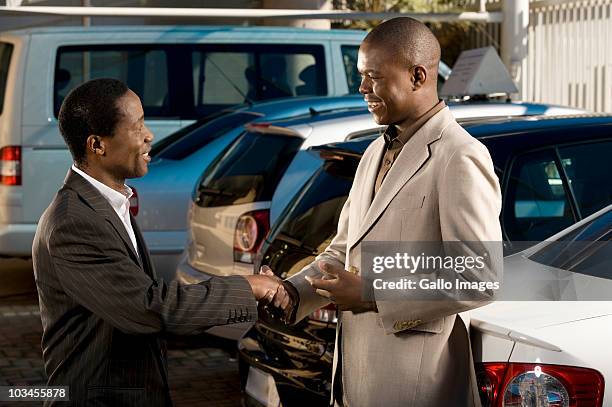 owners of car dealership shaking hands, johannesburg, south africa - johannesburg south africa stock pictures, royalty-free photos & images