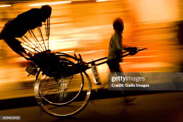 silhouette of rickshaw in motion at night, arashiyama, kyoto, honshu island, japan - rikscha stock-fotos und bilder