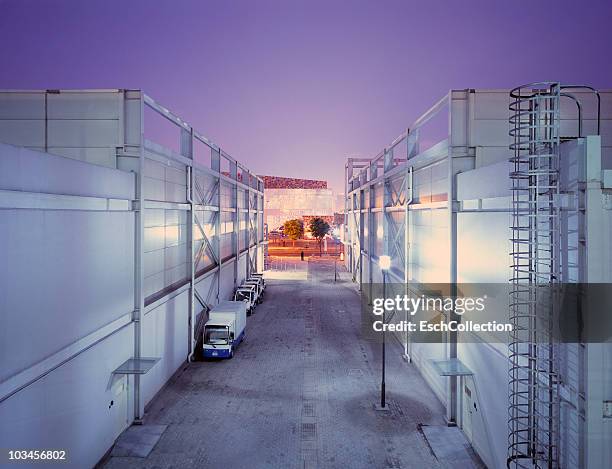 warehouse with electrical cars parked aside. - warehouse building exterior stock pictures, royalty-free photos & images