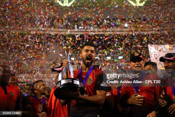 In this handout image provided by CPL T20, Ali Khan of Trinbago Knight Riders celebrates with the winners trophy during the Hero Caribbean Premier...