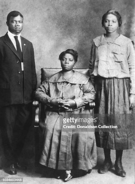 Jazz trumpeter and singer Louis Armstrong poses for a portrait with his mother Mary Albert and sister Beatrice 'Mama Lucy' Armstrong circa 1918 in...