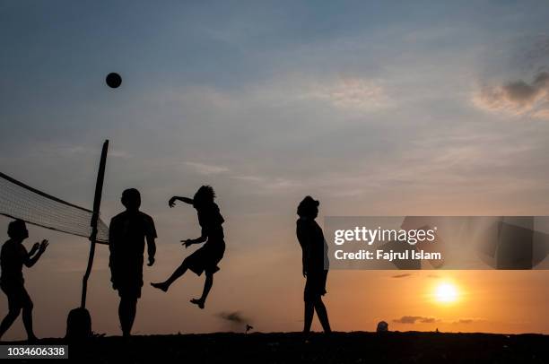 silhouette playing volleyball at beach - volley stock-fotos und bilder