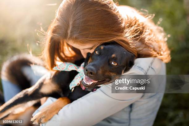 ragazza che abbraccia il suo cane - adoption foto e immagini stock