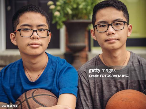 twins op basketbal - asian twins stockfoto's en -beelden